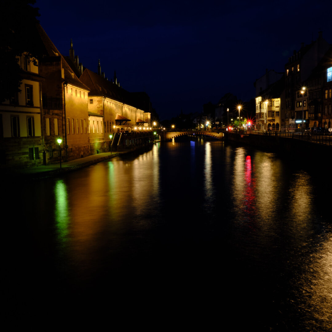 Long exposure photography of Strasbourg by night. The subject is the river and the building around