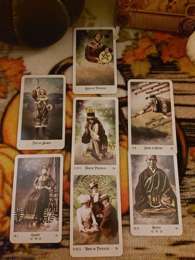 A tarot spread of 7 cards with vintage Images.
Queen of cups 
Chariot
Page of swords
Four of pentacles 
Three of pentacles
Eight of wands
The hermit