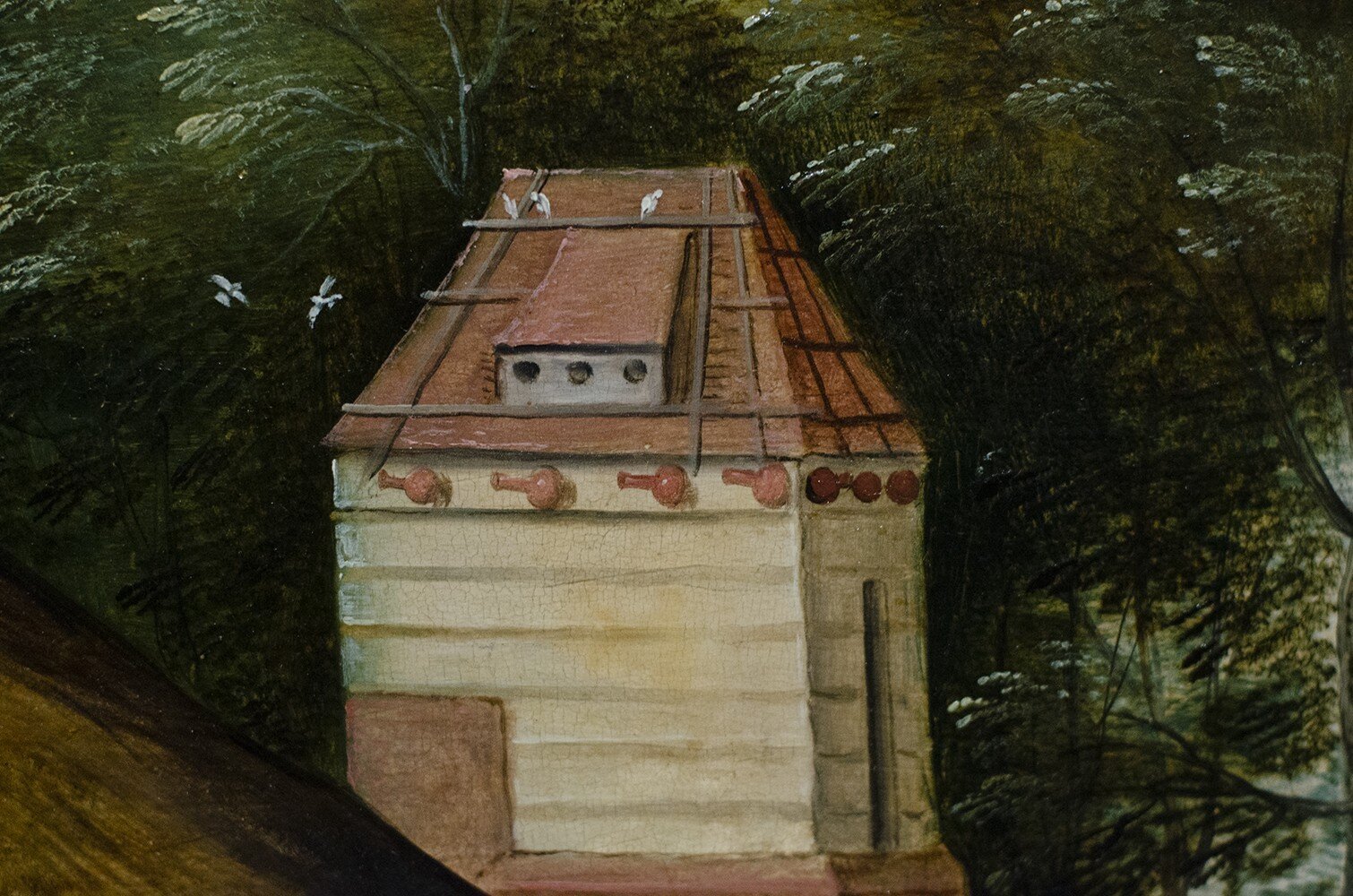 dark green treetops in the background with the upper part of a tower in front. White birds are circling around the tower. Along the edge of the tower roof there are round pots with large necks hanging in a row.