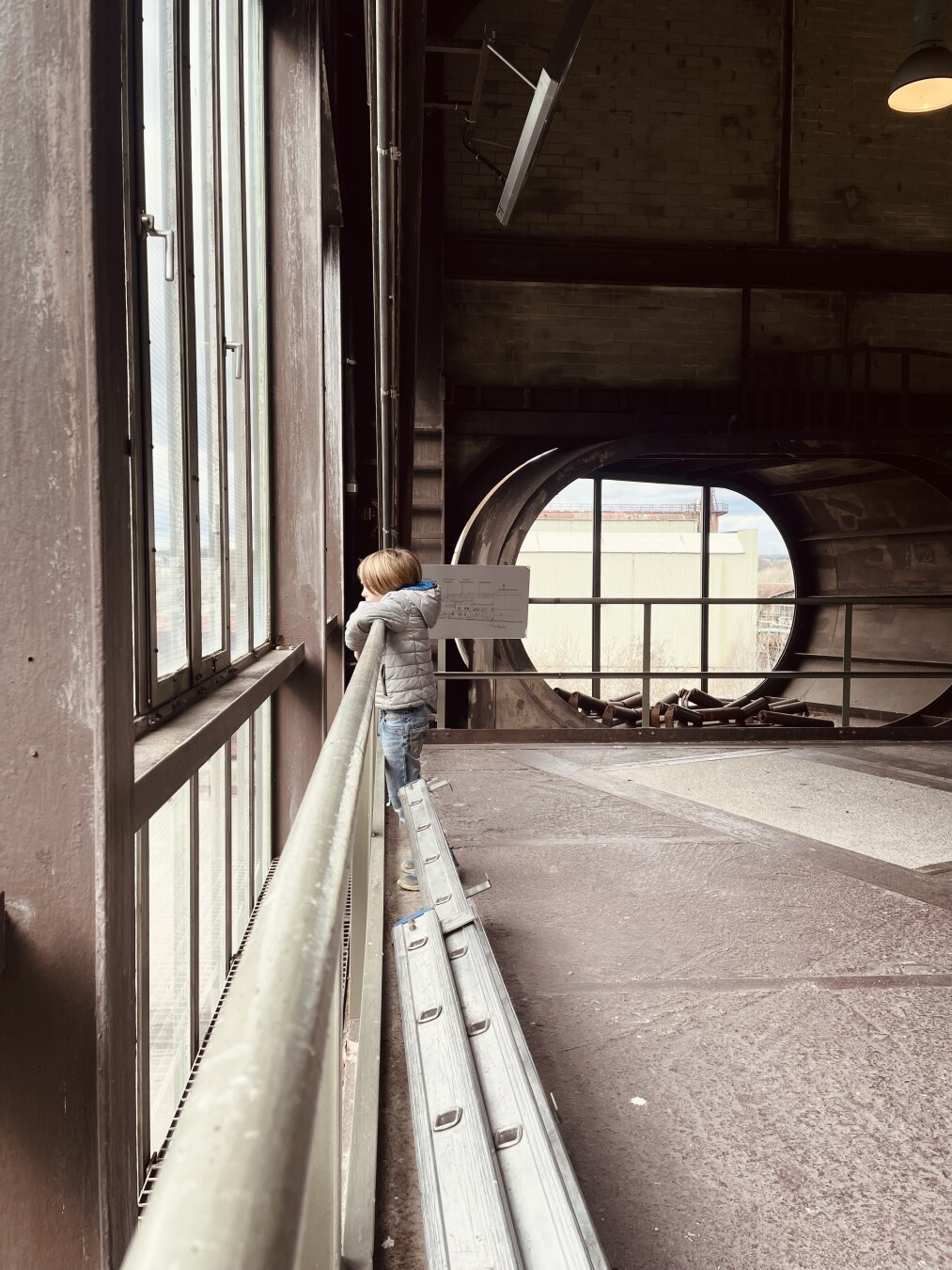 A child looking out of a window at the Henrichshütte at Hattingen. It‘s an old Steel Mill, what is now a museum.
