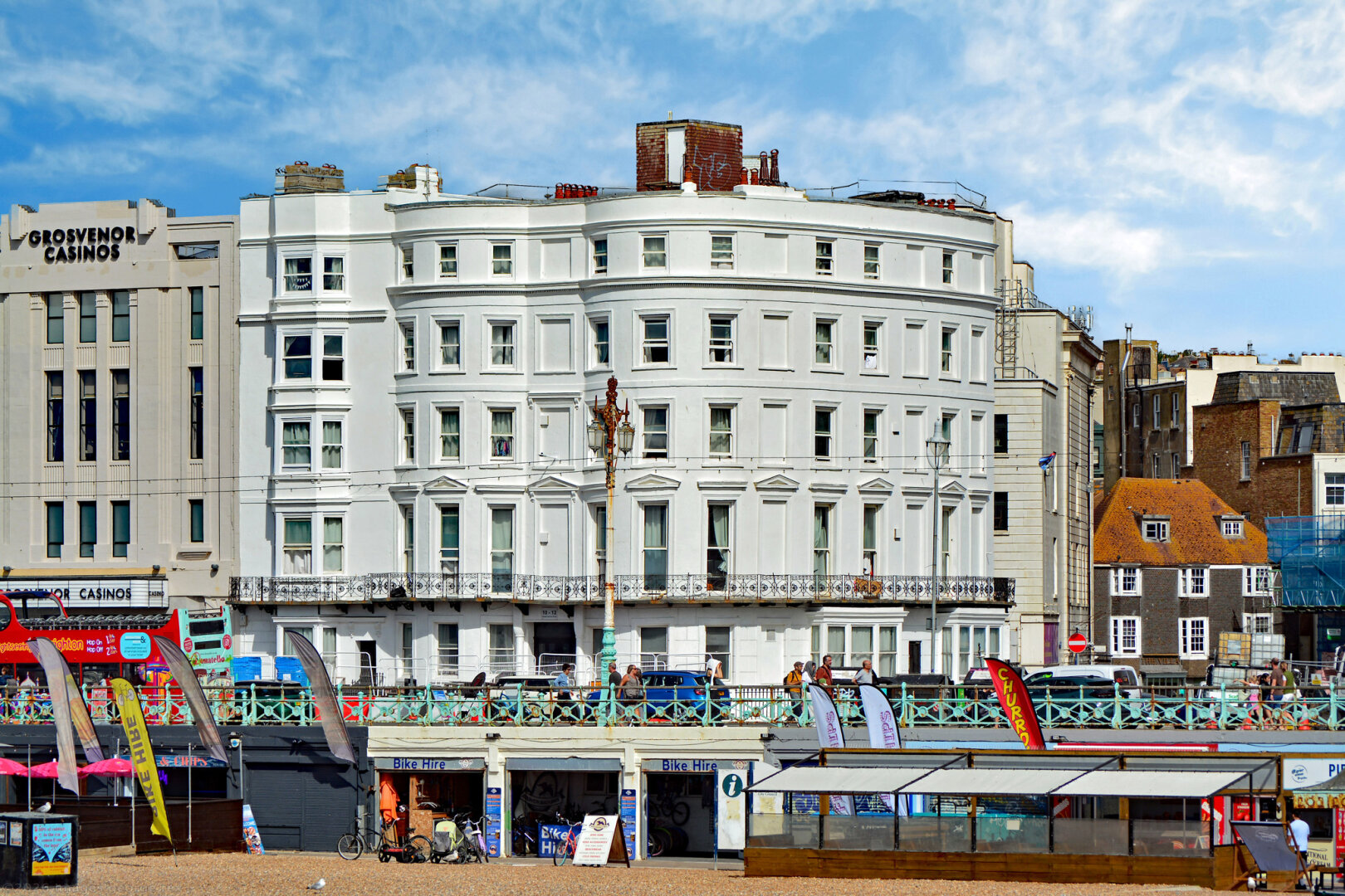 Photo of terraced houses, c.1840, 4 storeys and attic over basement. Continuous cast-iron balcony to first floor. Was Grade 2 listed as the Princes Hotel and has also been the Palace Hotel, now a hostel I believe. Victorian Italianate style, cream-painted stucco over brick. City of Brighton & Hove.