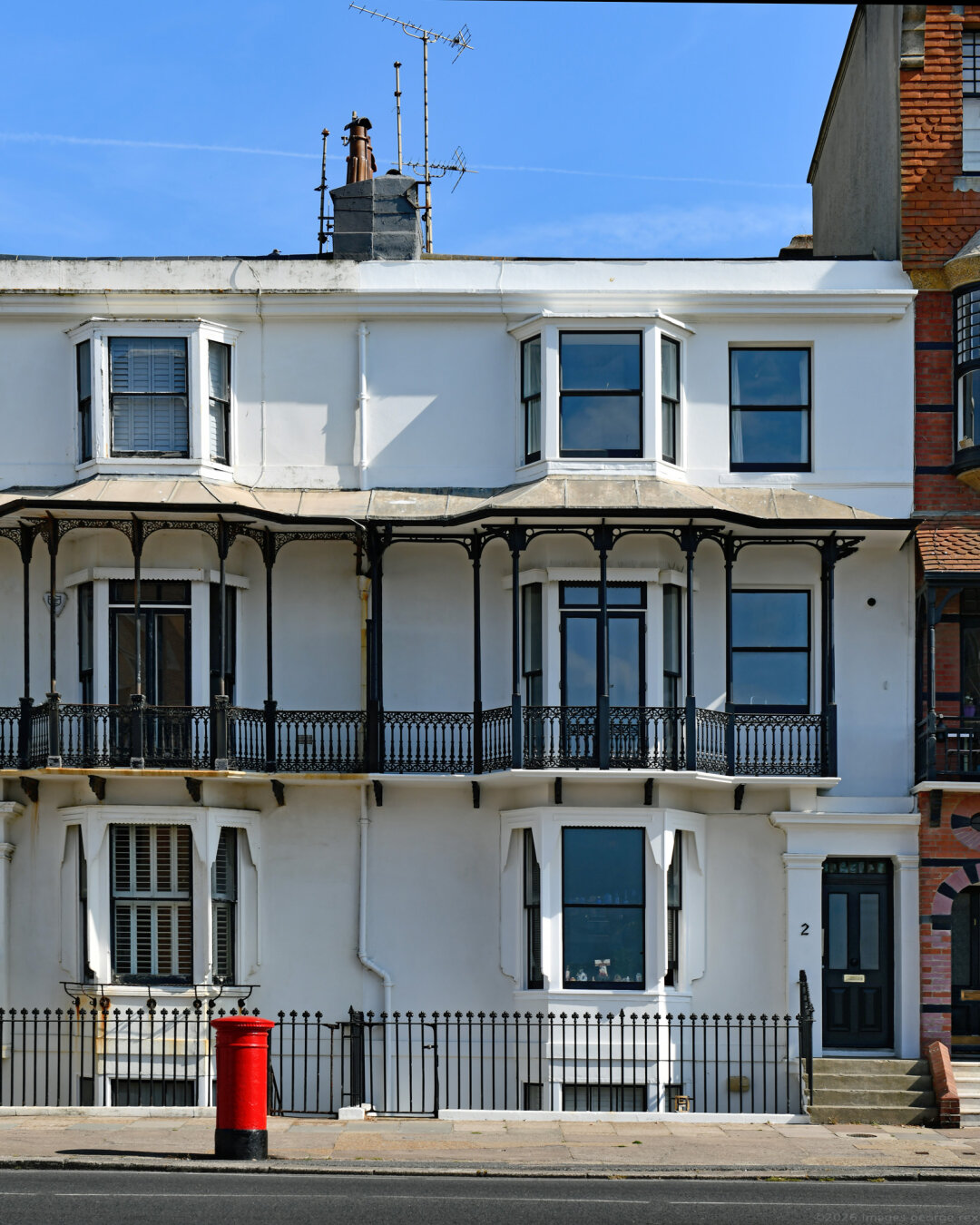 Photo of part of a Grade 2 listed terrace of dwellings built 1852-3, now flats. Render over brick, 3 storeys plus basement. Railings included in listing. Hove, City of Brighton & Hove.