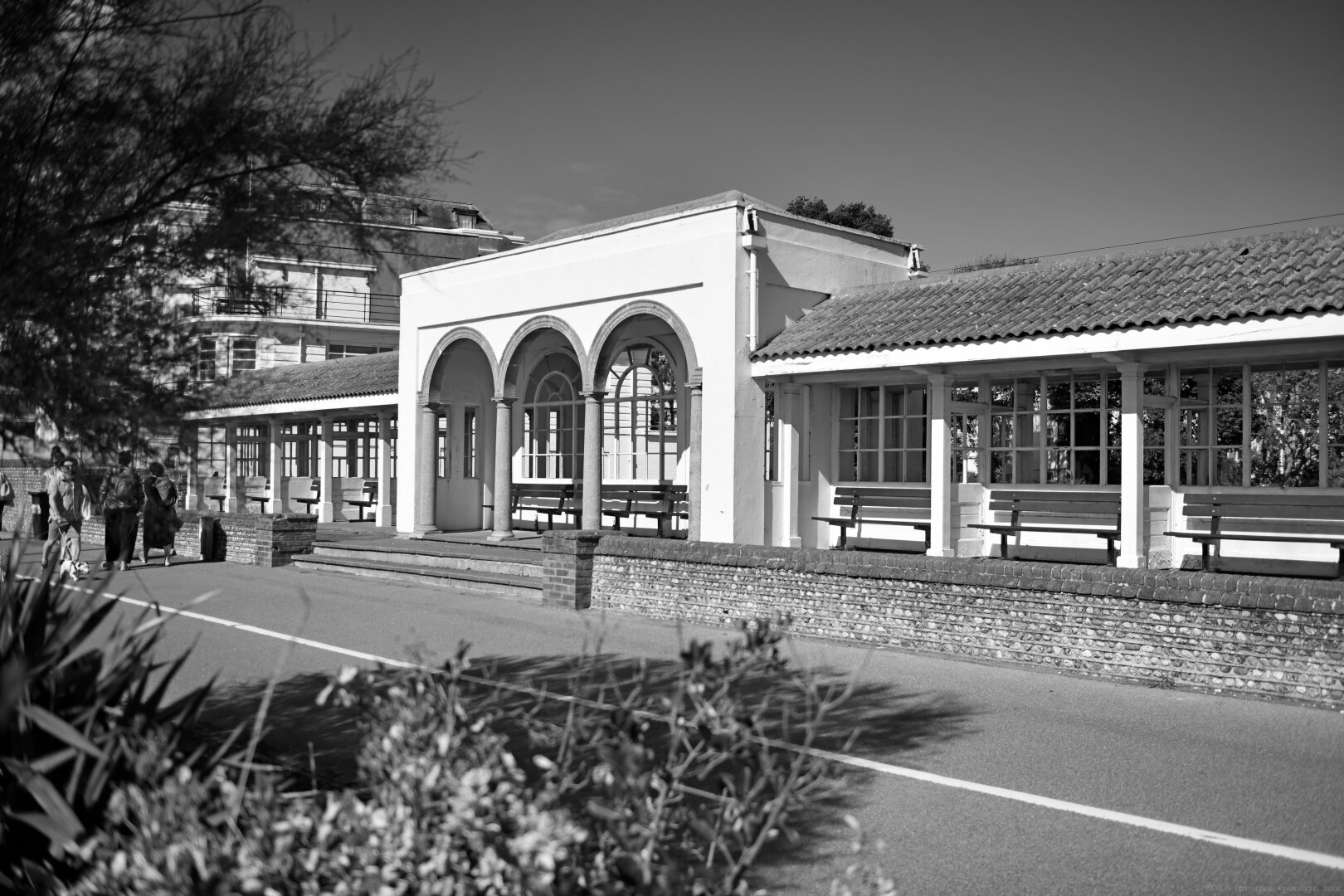 Photo of a pavilion flanked either side by additional shelters at the south end of Denton Gardens. Thought to have been built in the 1920s, possibly designed by borough architect C H Wallis. Within the Steyne Gardens Conservation Area, Worthing, West Sussex.