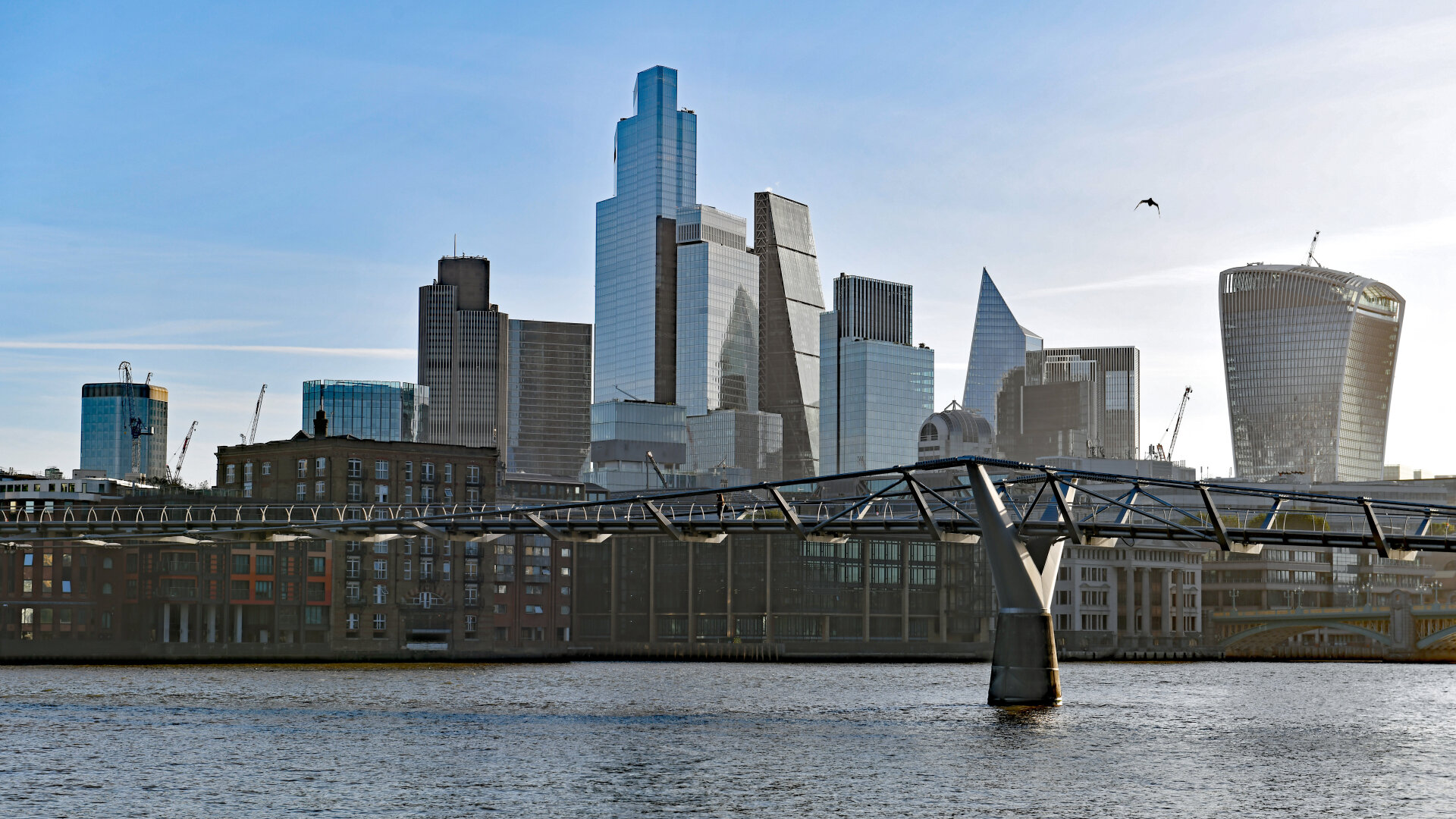 Photo of a view of the office towers in the City of London (plus the Millennium Bridge) from the south bank of the Thames in the London Borough of Southwark.