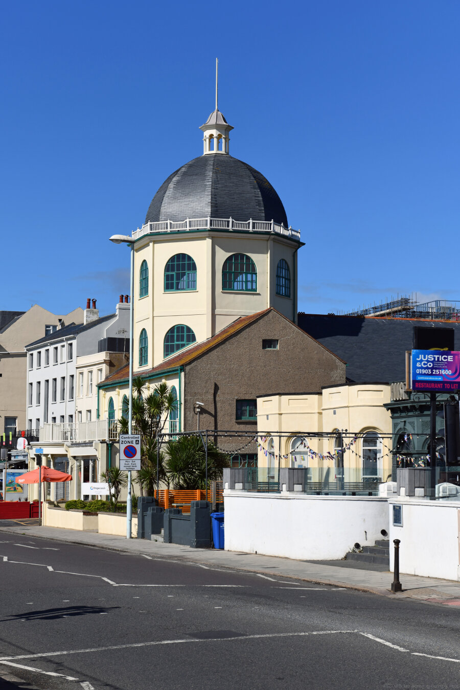 Photograph of a Grade 2* listed cinema with domed tower, designed by Theophilus Arthur Allen, 1911, in the Edwardian Baroque style. Said to be one of the best five early cinemas to survive in England. Here viewed from the southeast. Worthing Marine Parade, Sussex, UK.