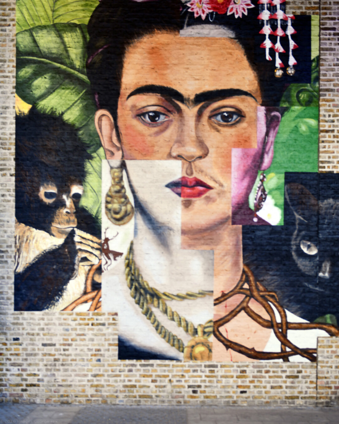 Photo of a mural painted by team Anysurface on the Thames Path near Blackfriars Station. Part of the city-wide public art trail celebrating the Tate Modern's "Frida: The Making of an Icon". Mural based on her "Self-Portrait with Thorn Necklace and Hummingbird, 1940". London Borough of Southwark.