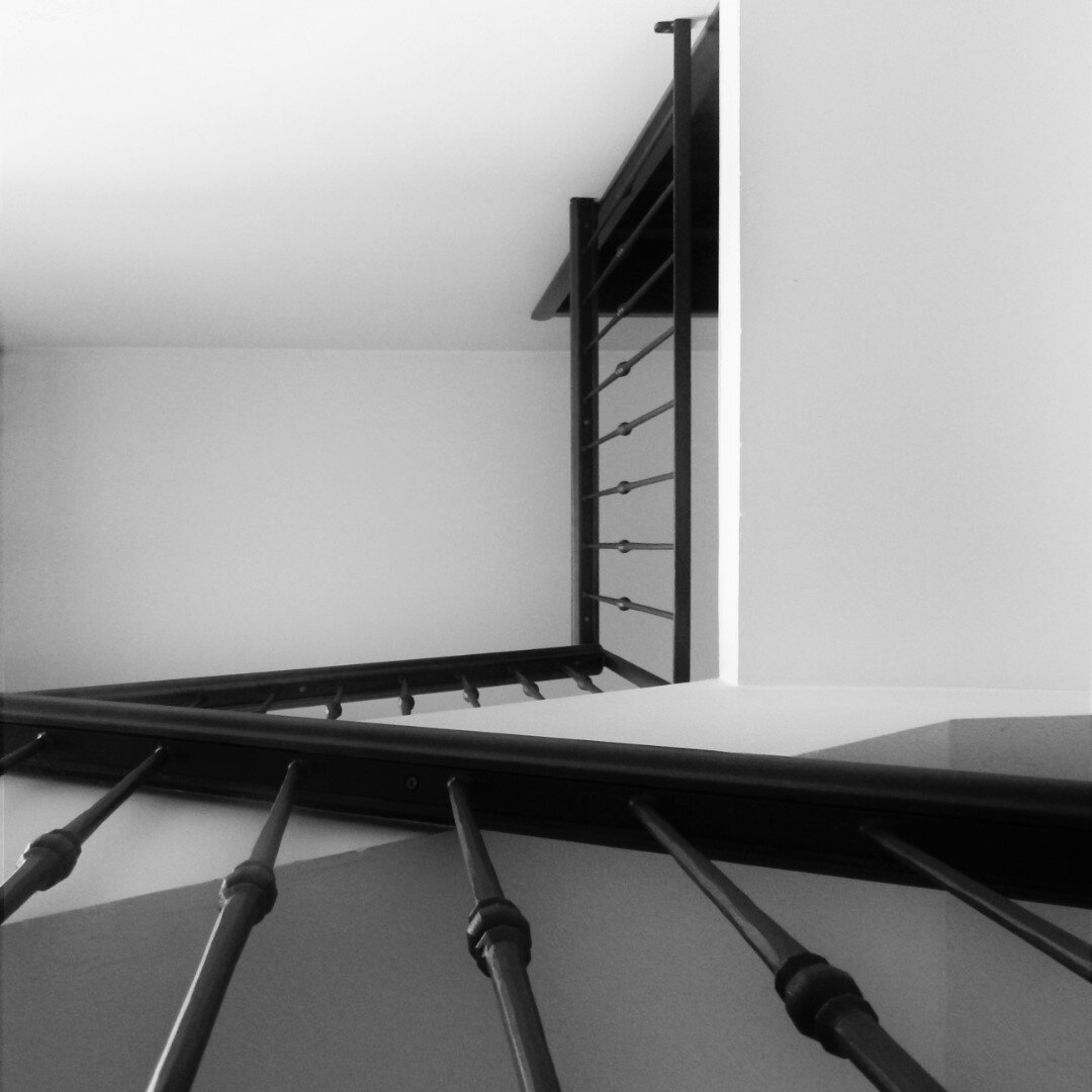 Staircase photographed from below with all the parallel iron lines to hold up the thing where you put your hand. Hi, I have a C1 English certification, but sometimes words don't word. I'll see myself out. Fuck. I will "see myself" in the alt text. Smooth, real smooth.