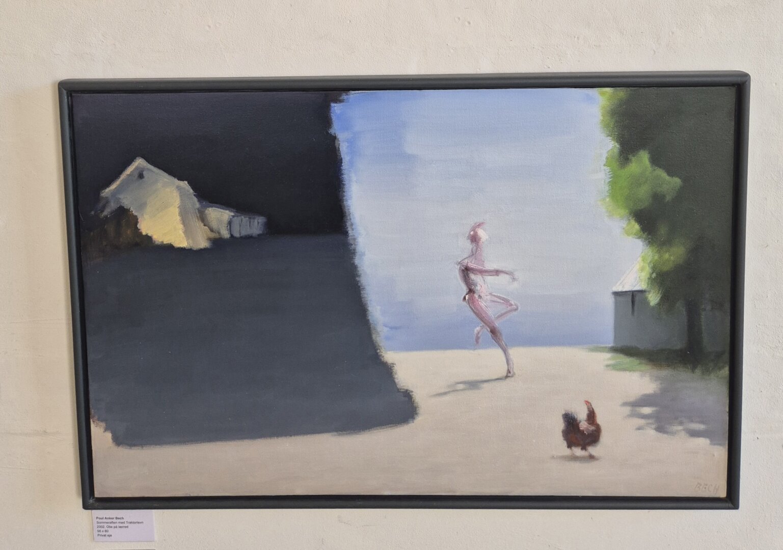 Framed landscape painting depicting a pink figur dancing across a sandy open area, with a rooster in the foreground and buildings and trees surrounding the scene.”