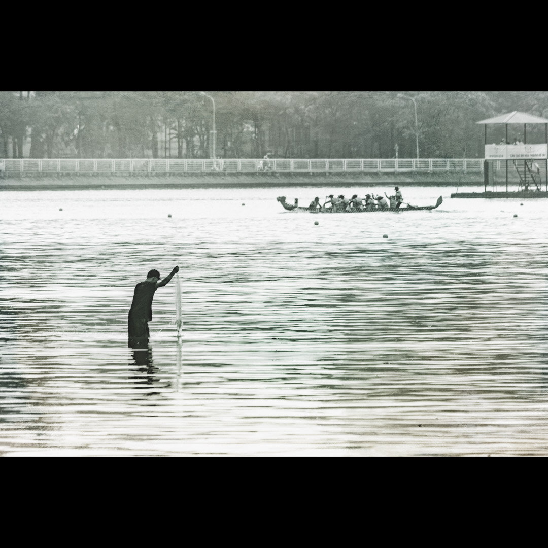 A fisherman in the Hanoï lake during a  dragon boats race, Vietnam