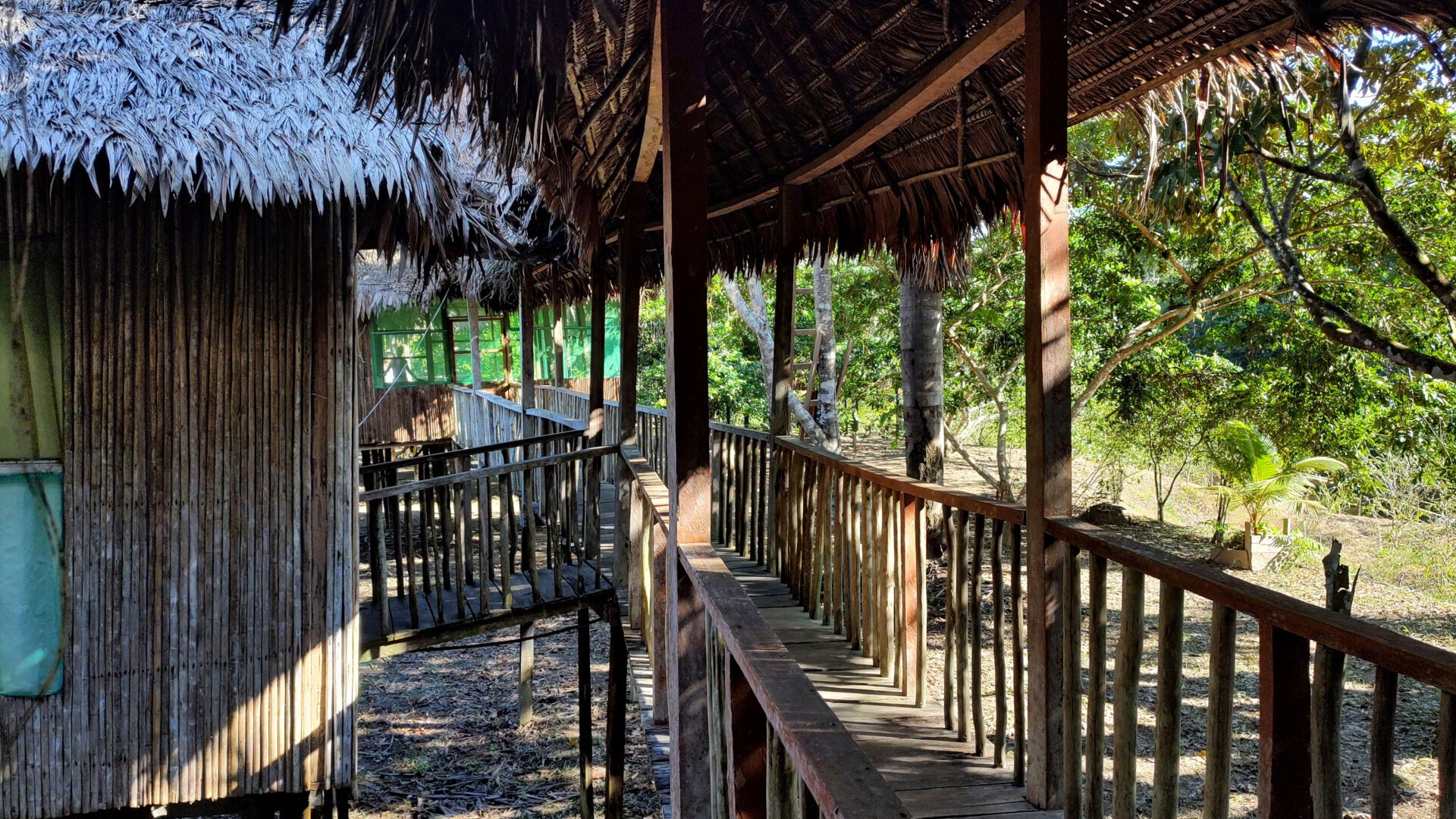 A footbridge branches out in the centre of the picture. One branch leads to a cabin, another part ends in the background in front of another cottage.