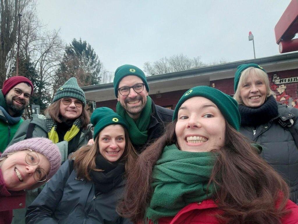 Fotografie eines Wahlkampfteams. Sieben Personen lächeln in die Kamera.