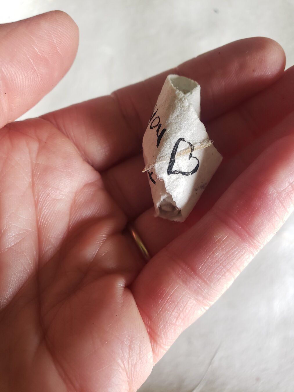 Artist Leslie Love holding a paper seed made with handmade ink and paper.