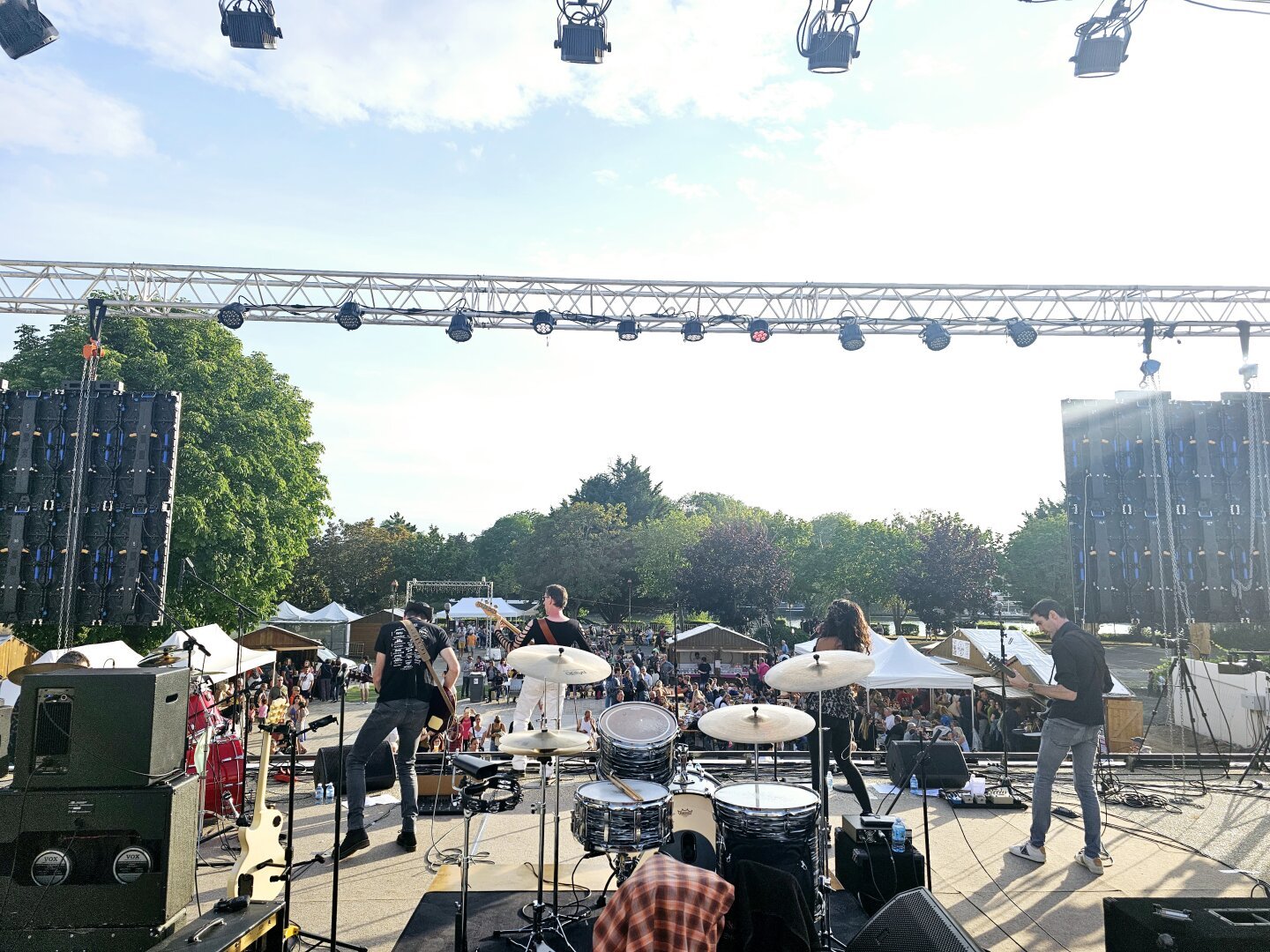 Groupe de rock vu de dos devant un public nombreux