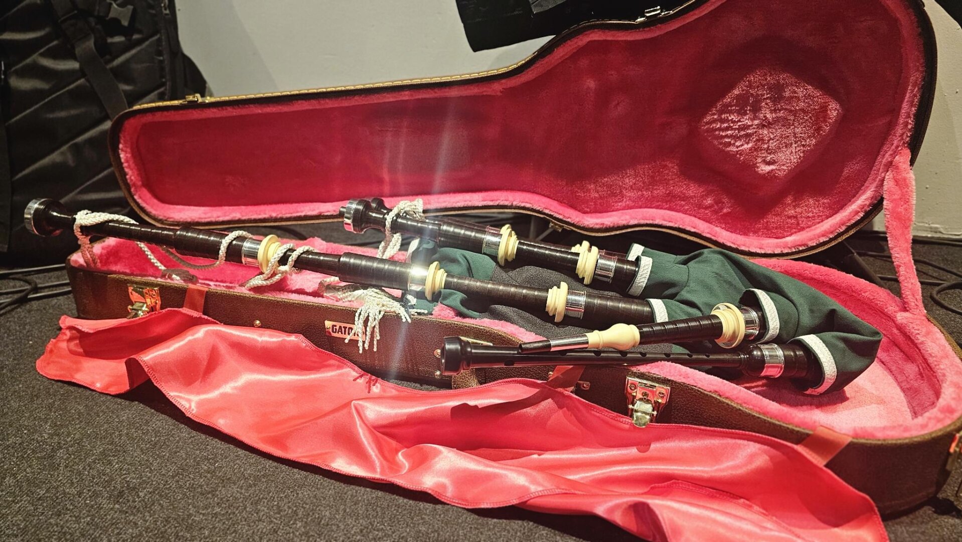 Une cornemuse dans un étui de guitare rose