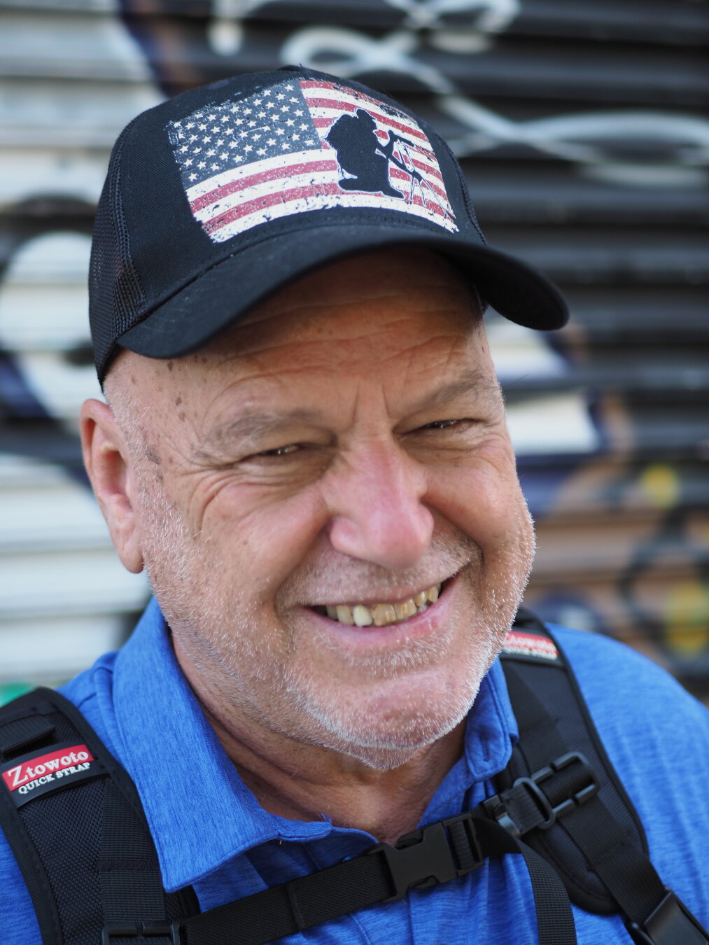 Street portrait of a smiling man in a black baseball cap