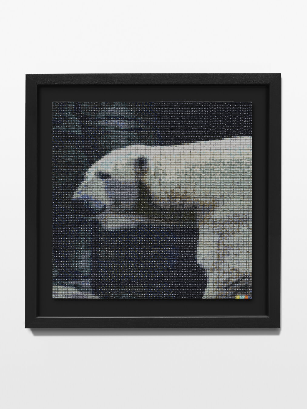 The image shows a polar bear running from right to left across the picture. Only the bear's head and part of its front shoulder are visible. In the background, you can see gray, dark rocks that are part of the architecture of a zoo enclosure. The image was created as a diamond painting and is framed on a black mat in a black wooden frame.