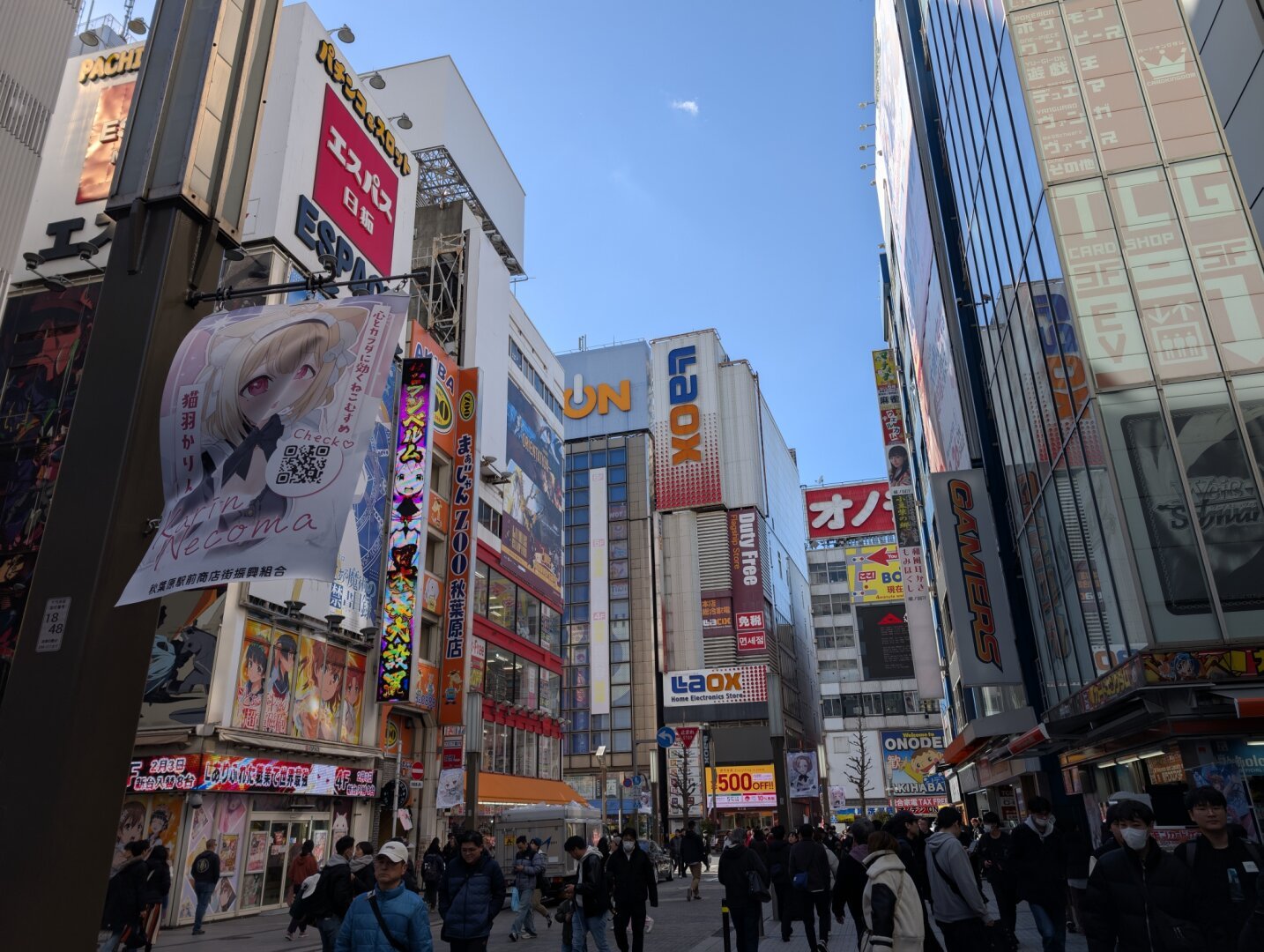 Buildings in Akihabara with lots of people walking in the street.