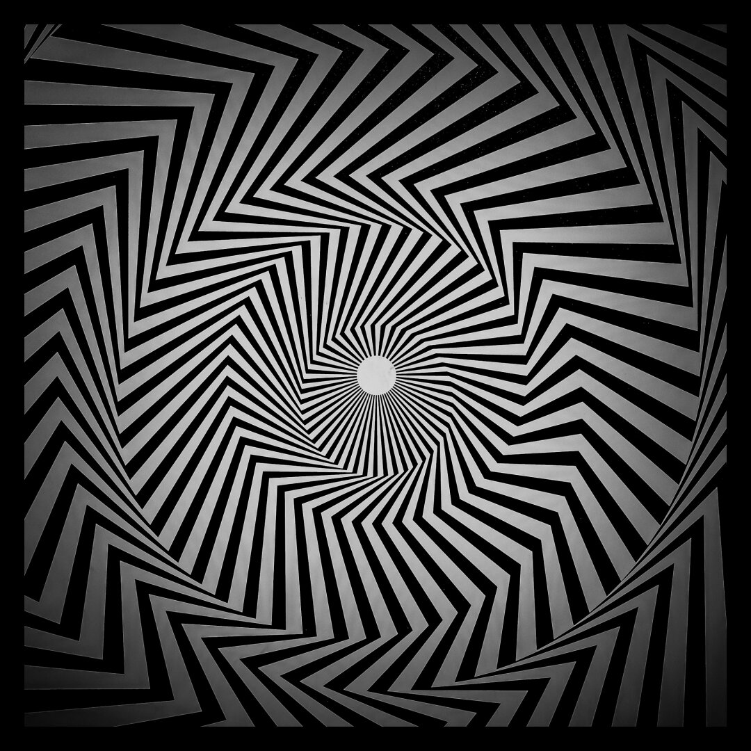 Black and white shot of an optical illusion swirling into the middle of the image. The outside has heavy vignetting.