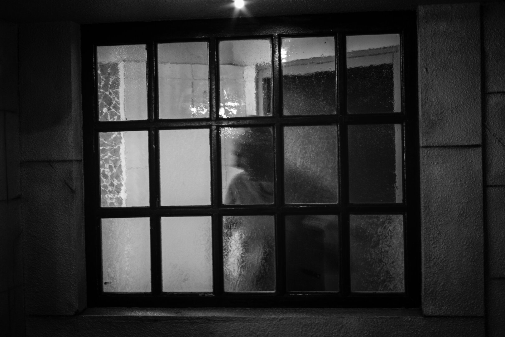 Silhouette prise à travers des vitres floues. Photo en noir et blanc