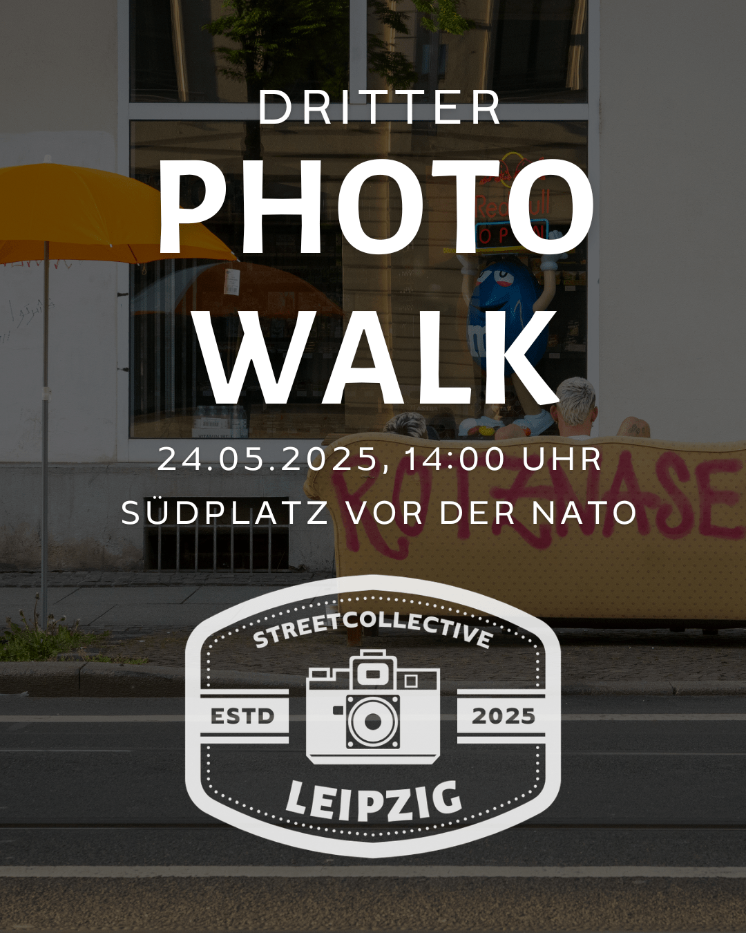 Blick auf die Rückseite einer Couch auf der Rotznasen steht. Neben einem Sonnenschirm vor einer Fassade.