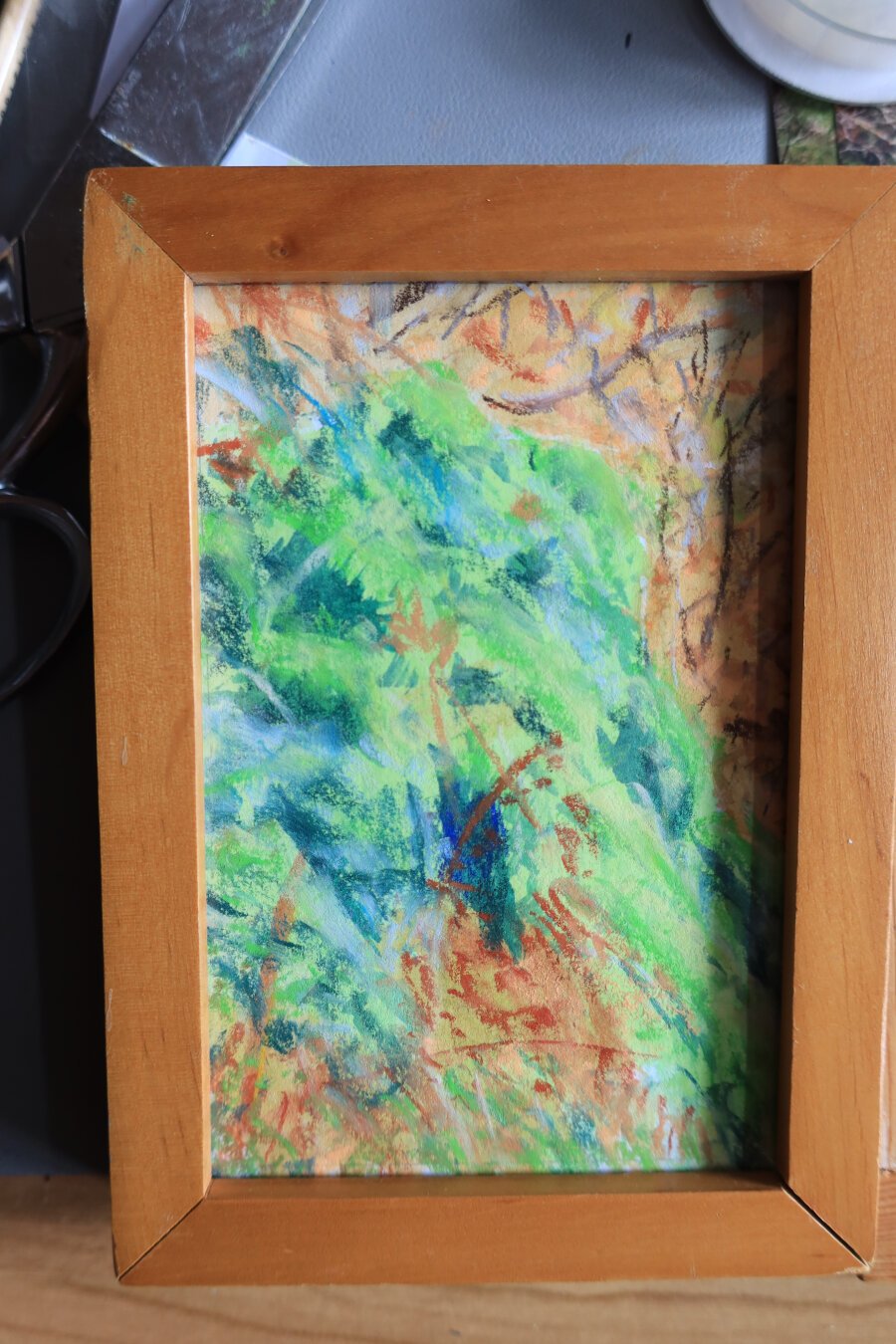 petit tableau vertical de sous-bois dans un cadre en bois fait à l'aquarelle et au pastel, dans des tons verts et orange