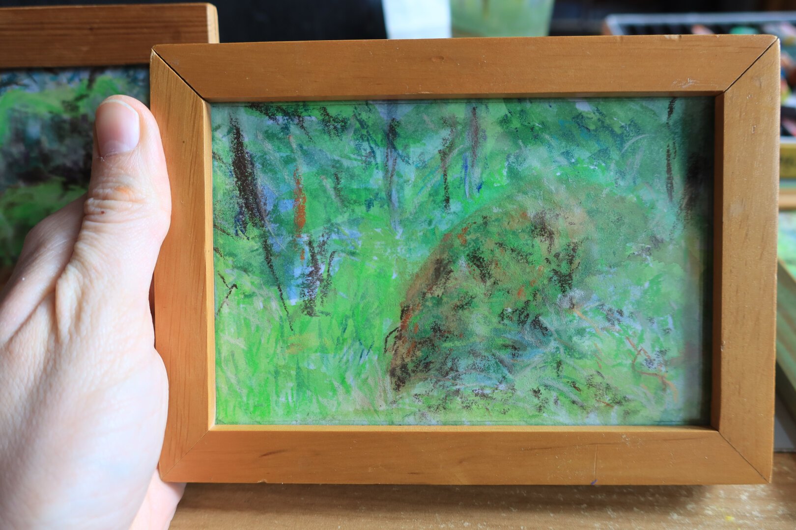 petit tableau horizontal  de sous-bois dans un cadre en bois fait à l'aquarelle et au pastel, dans des tons verts
