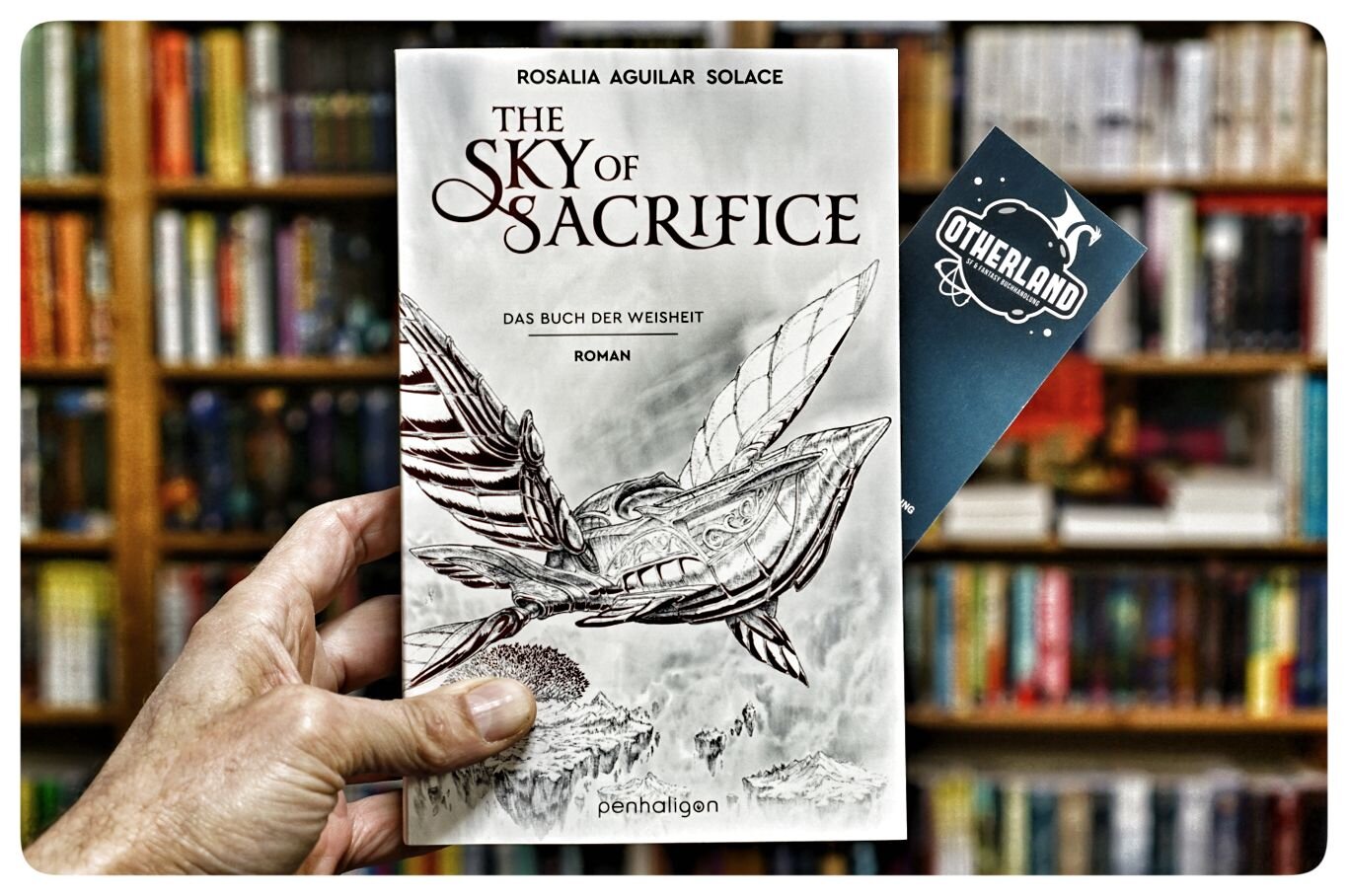 The Sky of Sacrifice - Buch der Weisheit-Trilogie (Band 2)
von Rosalia Aguilar Solace
Das Buch der Weisheit — Roman — Inspiriert vom grandiosen Musik-Festival Tomorrowland
übersetzt von Michaela Link

Der Vormarsch der Dunkelheit ist noch lange nicht vorbei – doch wo Schatten lauern, gibt es auch Licht. Und wo Licht ist, gibt es Hoffnung ...
In der Großen Bibliothek von Morgen kehrt nach dem Sieg über den Aschenmann wieder Frieden ein. Doch Nu, die neue Weise der Wahrheit, hat weder Zeit sich in ihrer Rolle einzuleben, noch sich mit ihren Gefühlen für Kollegin Triss zu beschäftigen: Ein Handlanger des Aschenmanns ist noch auf freiem Fuß, und seinem Herrn nach wie vor treu ergeben. Als das Buch der Weisheit ein unglaubliches Geheimnis aus der Vergangenheit enthüllt, reicht Hoffnung allein nicht aus: Nu und alle anderen Weisen müssen in die Weiten der Papierwelt ausziehen, um die tödliche Gefahr zu bezwingen, die am Horizont lauert ...