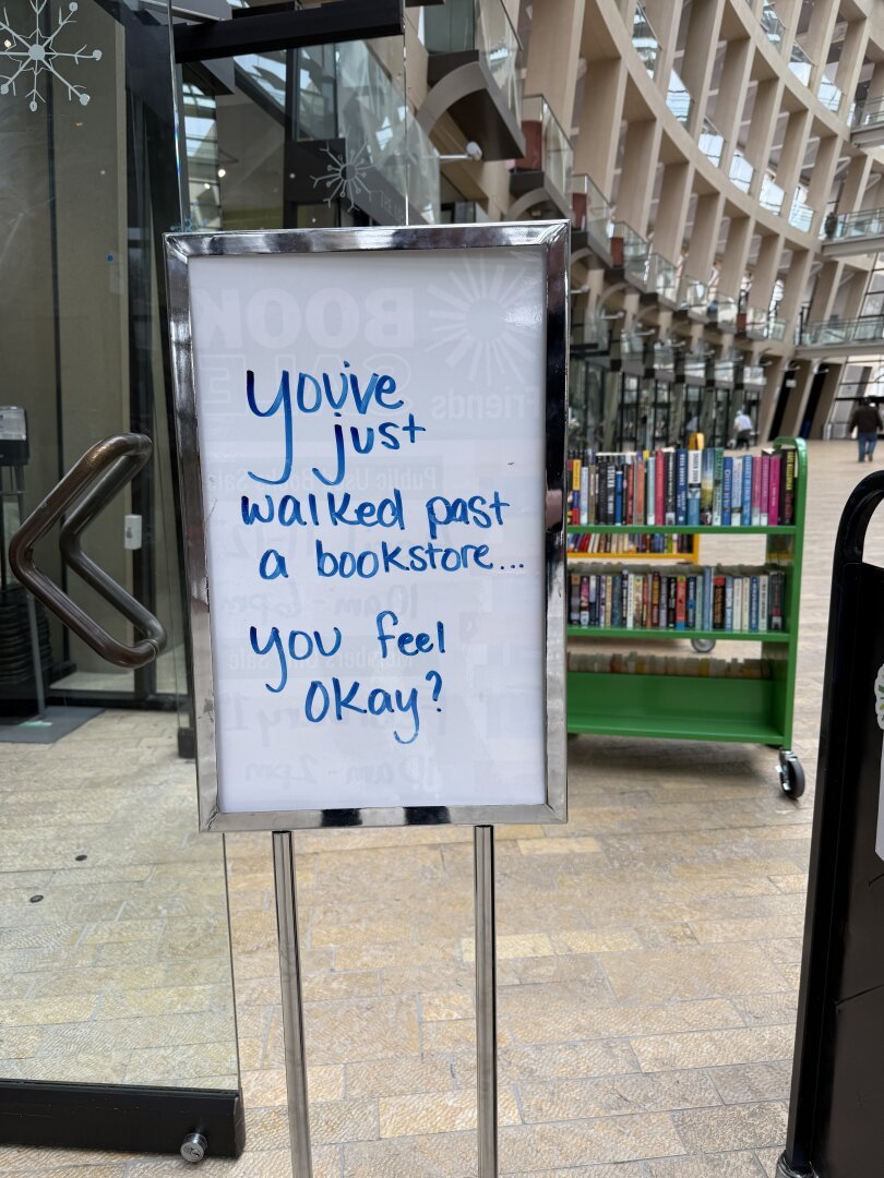 A sign outside a bookstore which reads, “You just walked past a bookstore…you feel okay?”