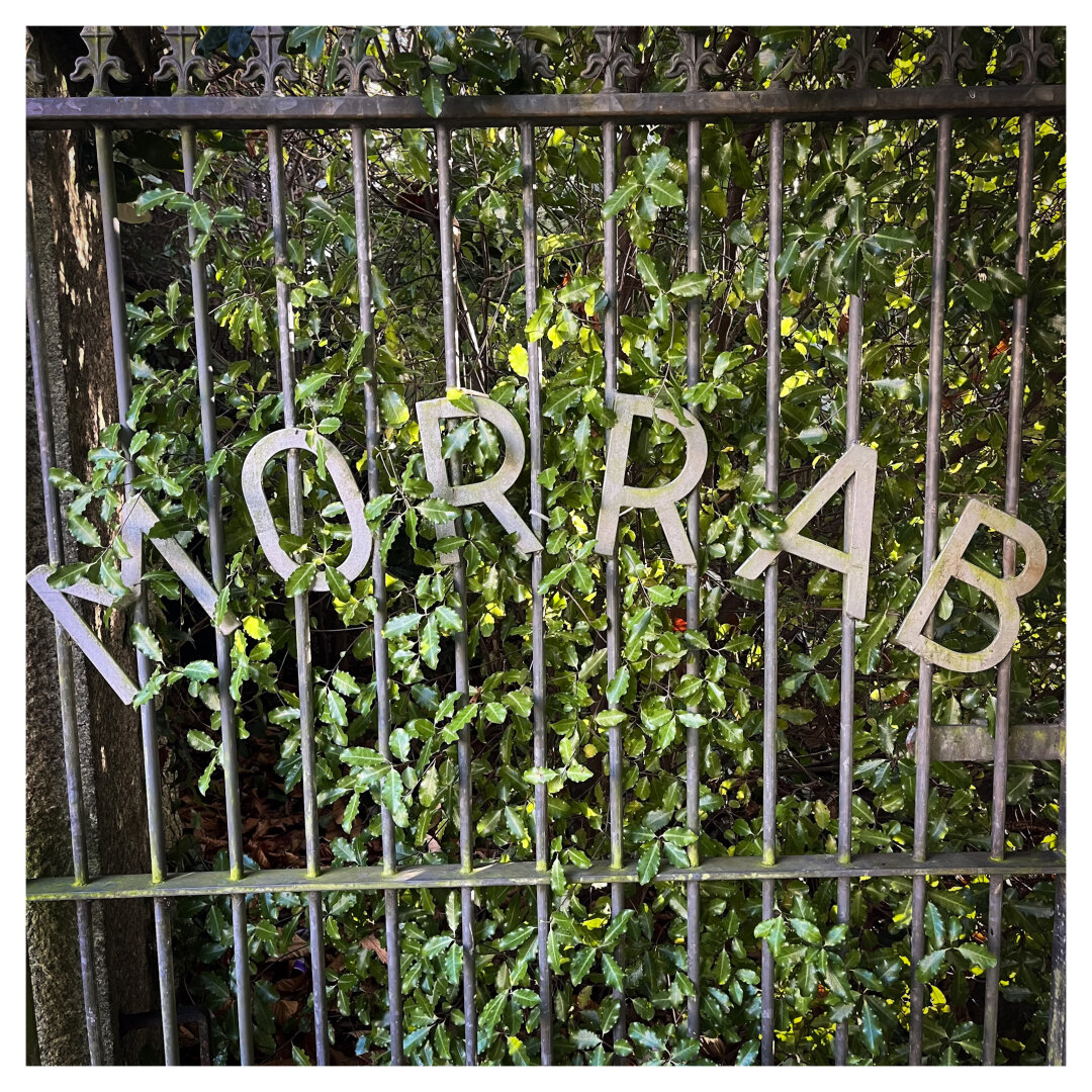 A gate sign against a green bushy background reads “Morab”