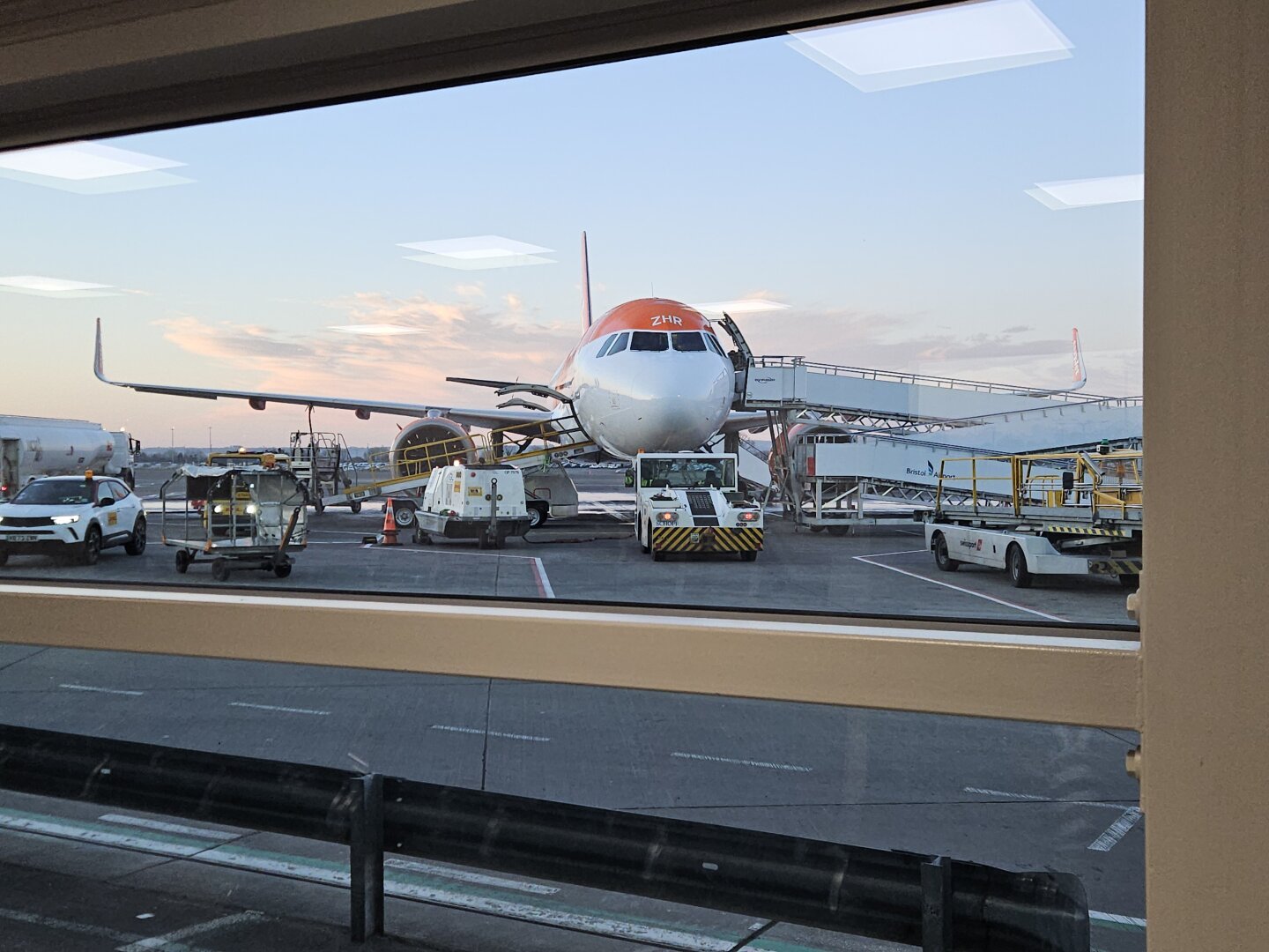A320 in orange and white easyJet livery with ground equipment connected