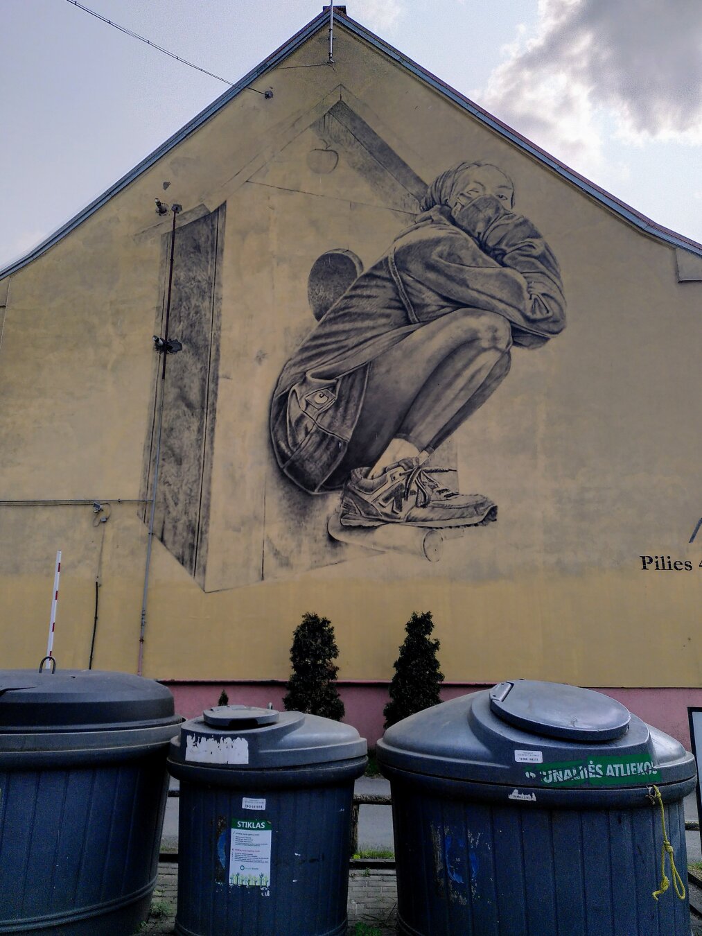 A woman is sitting in front of a small hut...