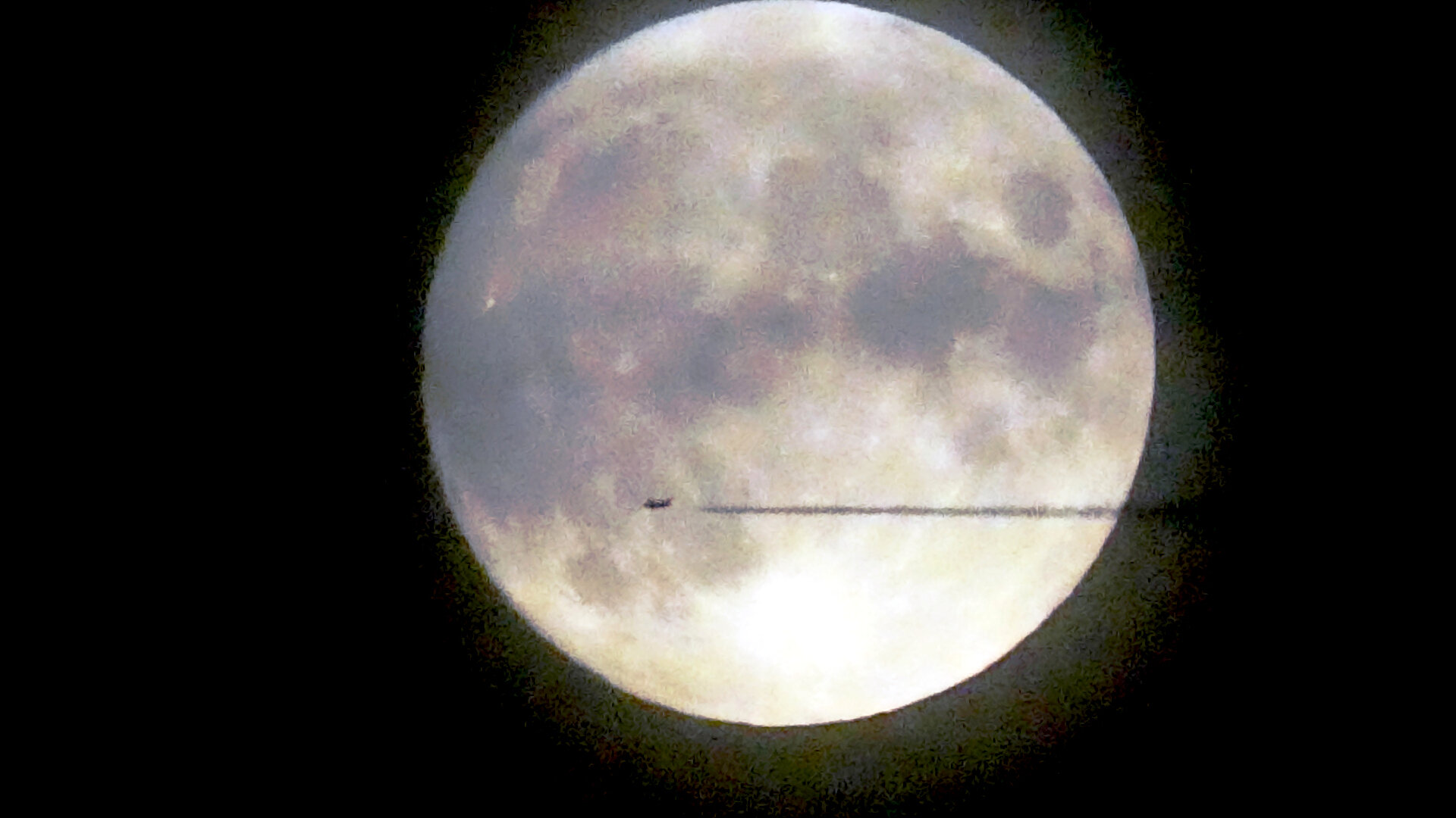 Am dunklen Himmel ist der volle Mond
Ein Flugzeug fliegt am Himmel mit Kondensstreifen, die durch den hellen Mond zu sehen sind.

The full moon is in the dark sky
An aeroplane flies across the sky, leaving contrails that are visible through the bright moon.