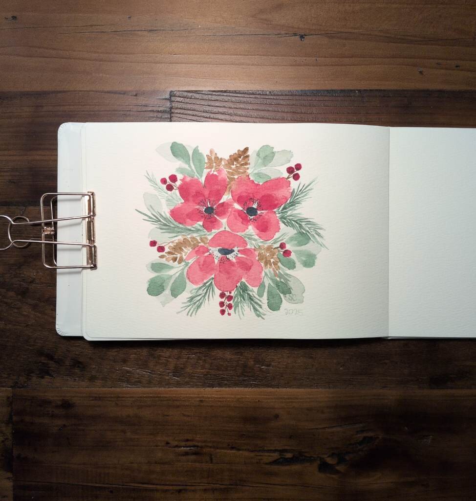 This is a watercolor floral arrangement in landscape orientation in an A5 sketchbook.  This floral artwork consists of three red anemones surrounded by wintery foliage; eucalyptus, pine cones, evergreen sprigs, and dark red berries.