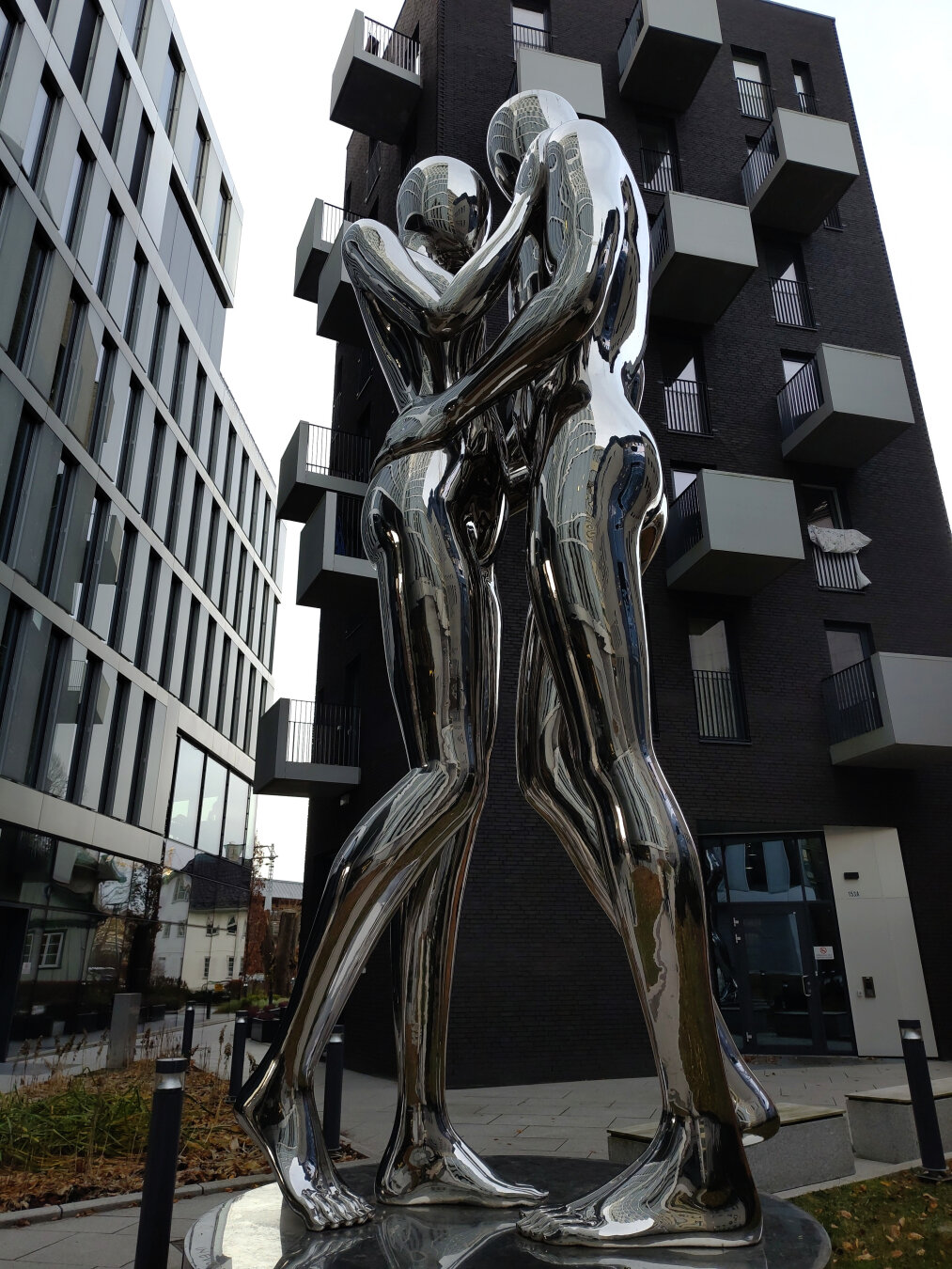 Металлическая скульптура на фоне современной архитектуры офисных зданий в Осло. Мужчина и женщина. Вместо лиц - овалы. Но их тела, руки и ноги переданы в реалистической манере. Влюбленные, застывшие в объятьях перед страстным поцелуем