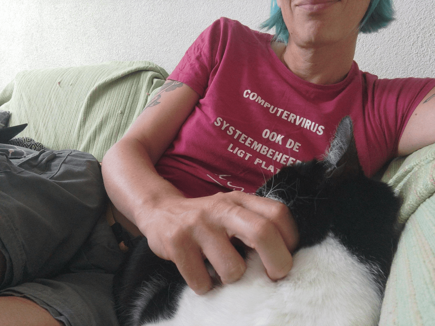 Photo of me, a black and white cat, lying next to my humanoid who is scratching me