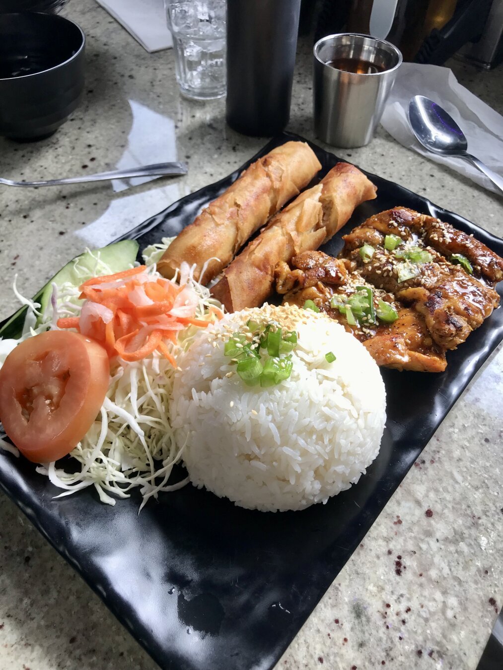 lemongrass chicken rice plate with salad and spring rolls