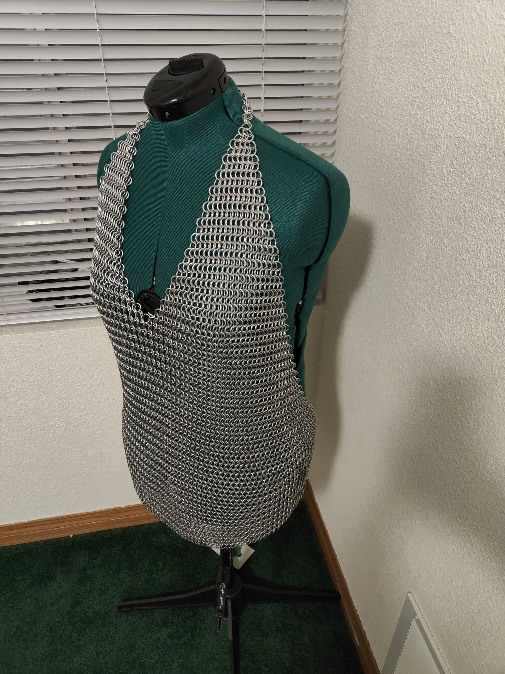 An angled front view of the chainmail shirt described in the post. It is modeled on a mannequin with a plain background.