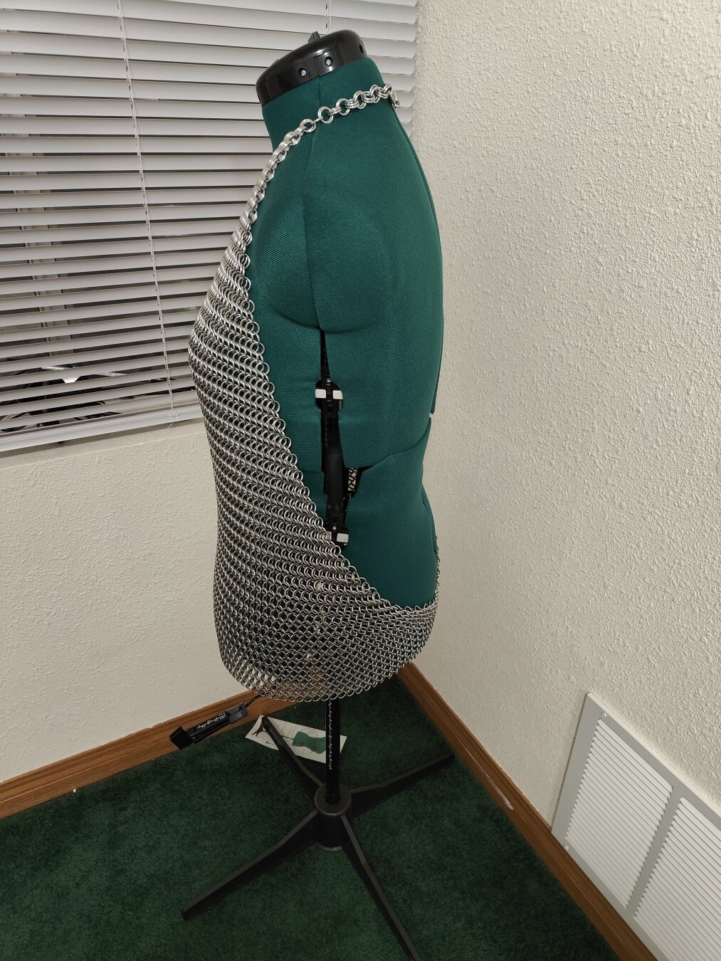 A side view of the chainmail shirt described in the post. It is modeled on a mannequin with a plain background.