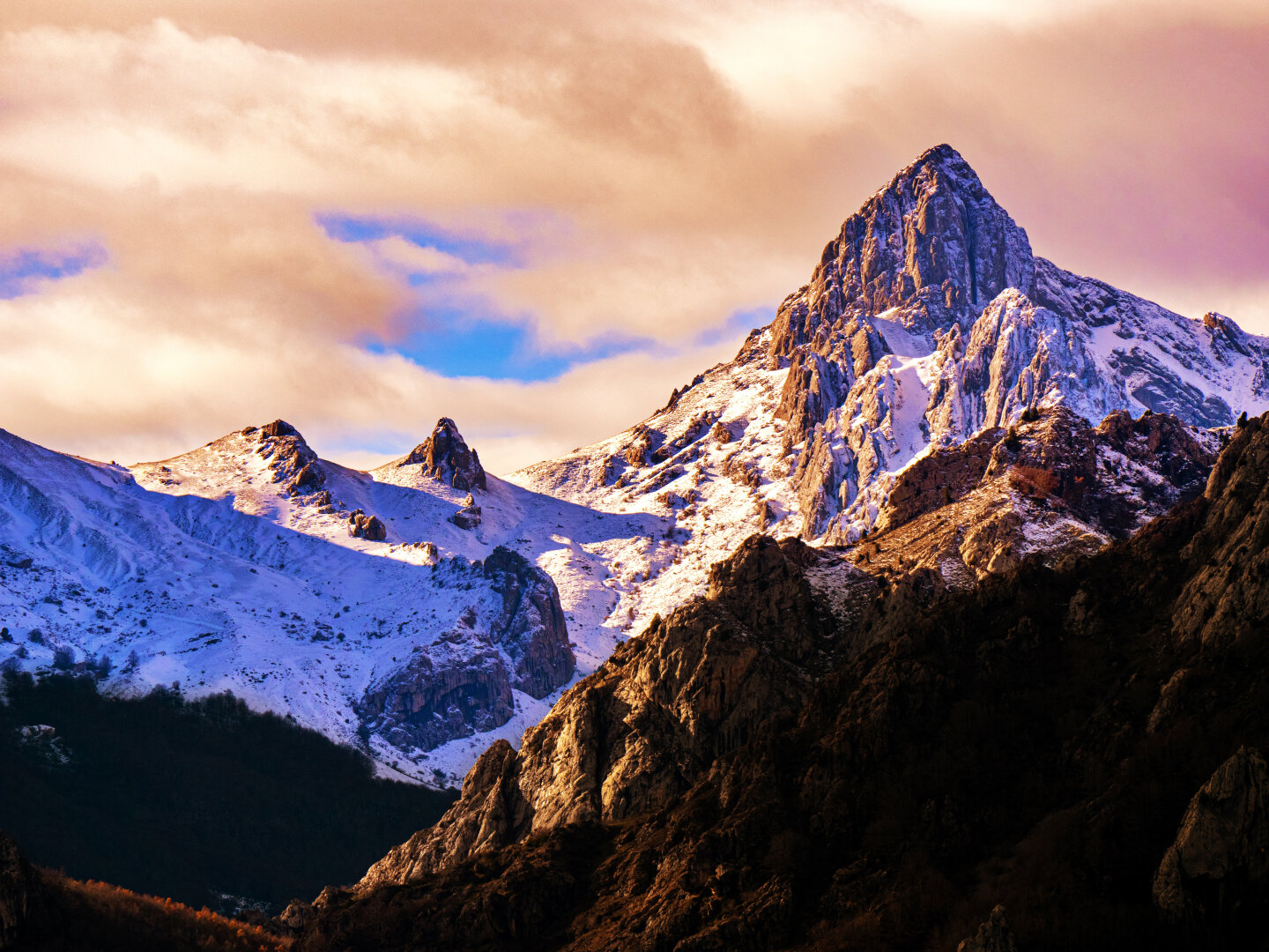 𝗣𝗶𝗰𝘁𝘂𝗿𝗲 𝗗𝗲𝘀𝗰𝗿𝗶𝗽𝘁𝗶𝗼𝗻 (𝗘𝗻𝗴): Llerenes Peak in the Montaña de Riaño y Mampodre Regional Park, León, partially covered by fresh snow. The rocky summit rises beneath a dramatic pink and blue sky. The snow-covered slopes contrast with darker areas of forest and bare crags in the lower part of the image.

𝗗𝗲𝘀𝗰𝗿𝗶𝗽𝗰𝗶𝗼́𝗻 (𝗘𝘀𝗽): Pico Llerenes en el Parque Regional de la Montaña de Riaño y Mampodre, León, parcialmente cubierto por la nieve recién caída. La cumbre rocosa se eleva bajo un dramático cielo de rosa y azul. Las laderas nevadas contrastan con zonas más oscuras de los bosque y los riscos desnudos en la parte inferior de la imagen.