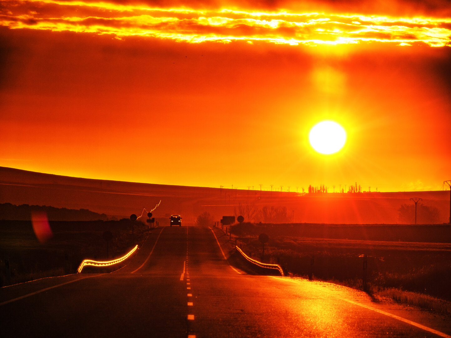 𝗣𝗶𝗰𝘁𝘂𝗿𝗲 𝗗𝗲𝘀𝗰𝗿𝗶𝗽𝘁𝗶𝗼𝗻 (𝗘𝗻𝗴): Dawn breaks on a gently undulating road stretching towards the horizon. The incandescent sun shines low in the sky. The golden sky hangs over a road between fields, backlit by several vehicles.

𝗗𝗲𝘀𝗰𝗿𝗶𝗽𝗰𝗶𝗼́𝗻 (𝗘𝘀𝗽): Amanecer en una carretera suavemente ondulada que se extiende hacia el horizonte. El sol incandescente brilla bajo en el cielo. El cielo dorado sobre una carretera entre campos a contraluz y varios vehículos circulan por la vía.