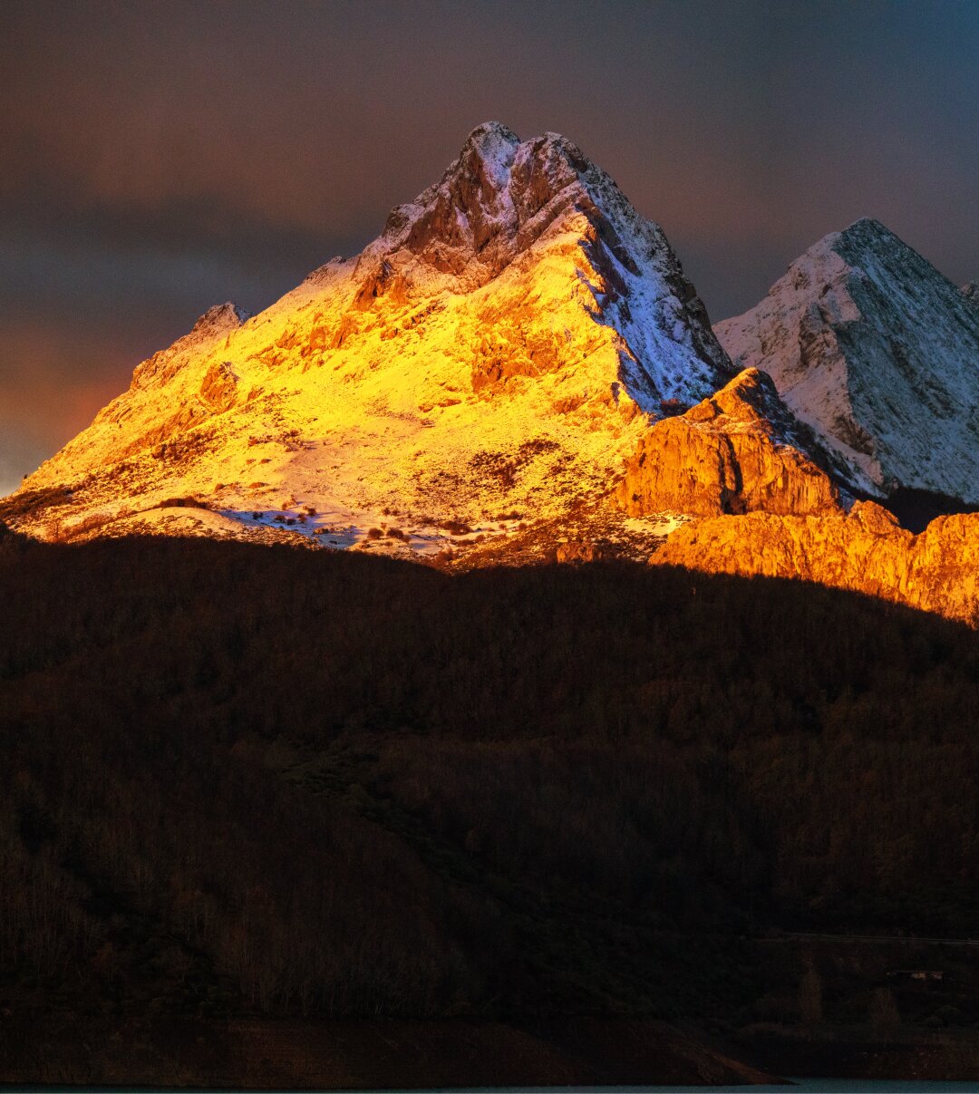𝗣𝗶𝗰𝘁𝘂𝗿𝗲 𝗗𝗲𝘀𝗰𝗿𝗶𝗽𝘁𝗶𝗼𝗻 (𝗘𝗻𝗴): Gilbo peak illuminated by the rising sun, with the summit of Llerenes still in shadow behind it. The dark mass of vegetation below is the Canal Moro beech forest.

𝗗𝗲𝘀𝗰𝗿𝗶𝗽𝗰𝗶𝗼́𝗻 (𝗘𝘀𝗽): El Pico Gilbo iluminado por el sol naciente, detrás, aún en la sombra, el Llerenes. La masa oscura de vegetación que hay en la parte inferior es el Hayedo de Canal Moro.