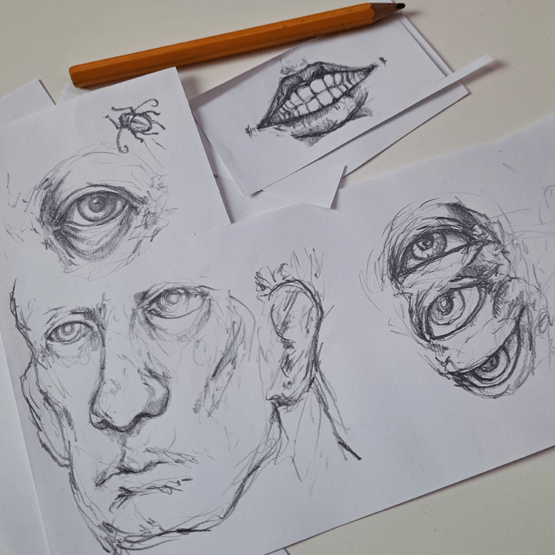 A photo of cut, leftover pieces copy paper with pencil sketches and doodles of eyes, a mouth and a face. A pencil is laying next to them.