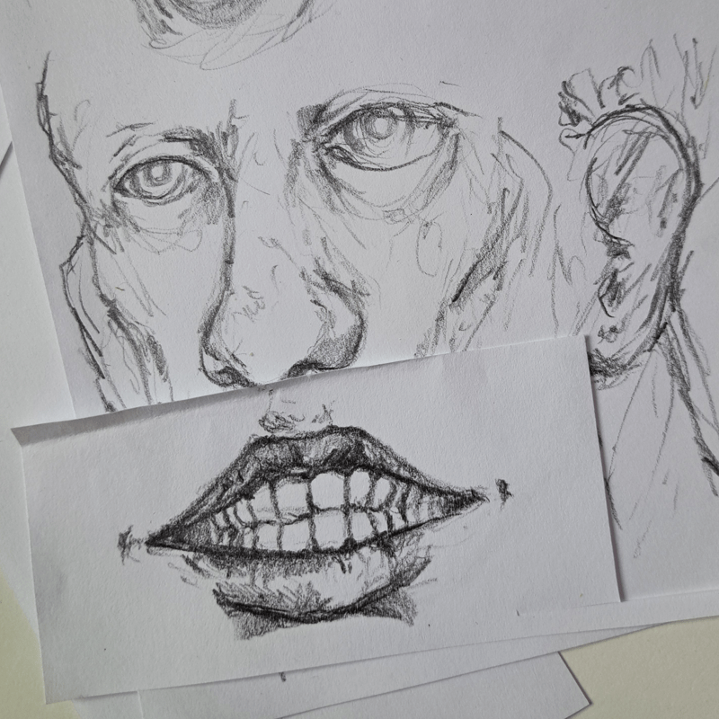 A quick pencil drawing of a face, with a drawing of a mouth put on top of it, changing the face's expression and making it look more silly.