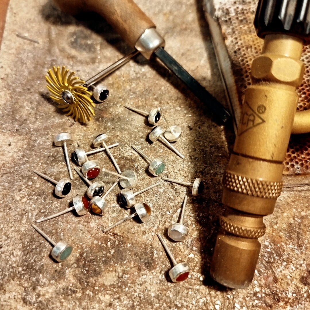unfinished small stud earrings and silversmith's tools