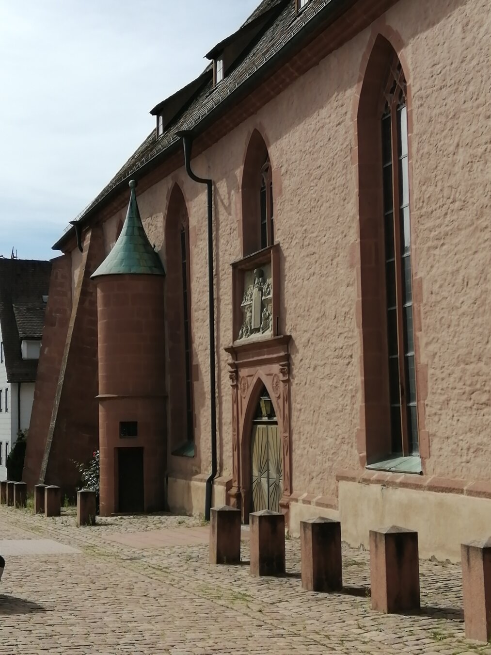 Kirchenwand mit einem kleinen, angebauten Turm mit Tür