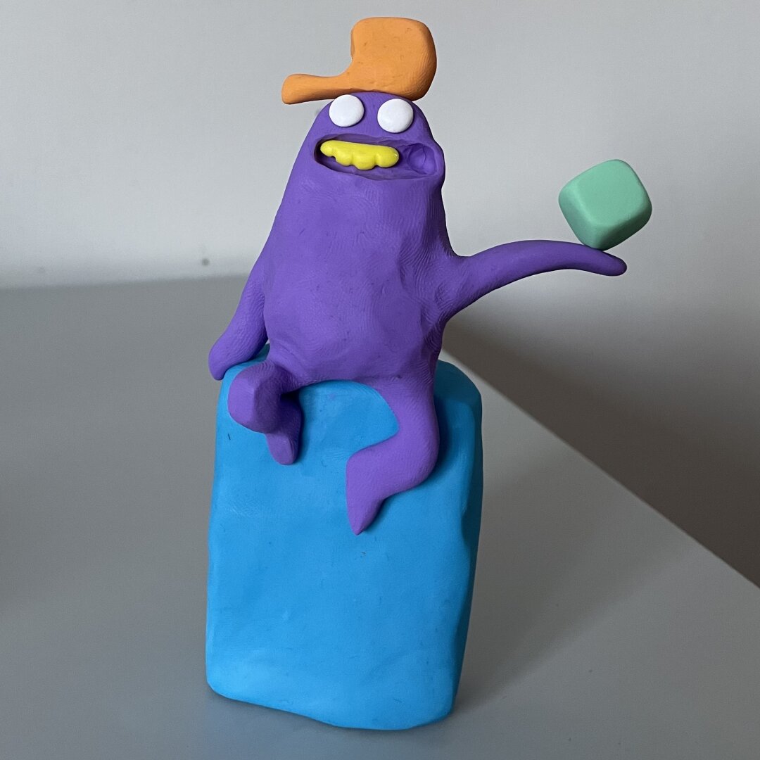 A crazy clay character holding a cube