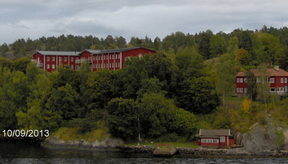 Big, medium and small red homes on a tall forested island
