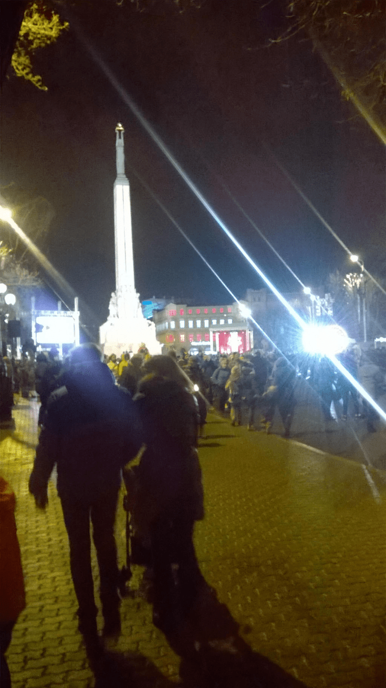 The Monument of Freedom further away, lit up the bright lights and concert happening by it, surrounded by swarms of people