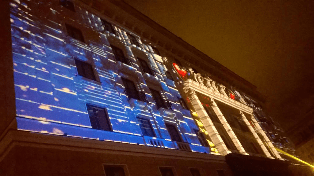 Hotel facade, lit up with blue flames and golden lights