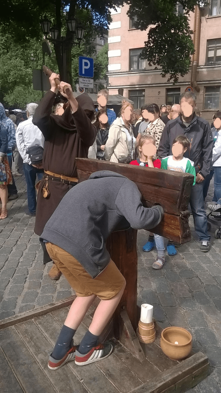 A young guy is in the stocks, the axe again raised high